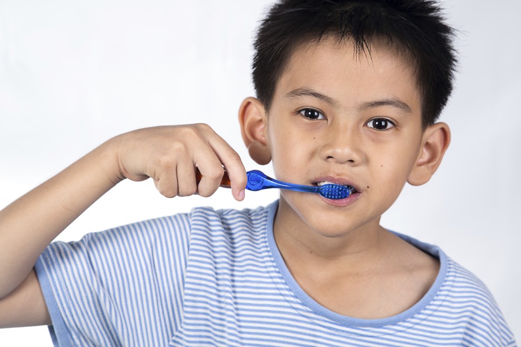 boy brushing teeth, on white