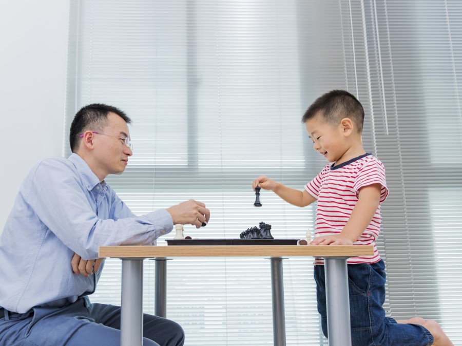 Father and son playing chess.